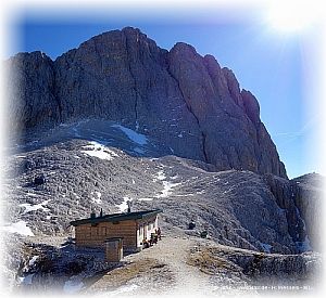 Die Santnerpass Hütte und dahinter die Rosengartenspitze.